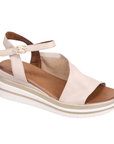 Beige sandal with slingback and open toe d'Orsay style upper with gold buckle, white and gold lined wedge midsole and tan Bueno logo'd footbed.