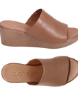 Pair of Brown slide sandals with brown wedge outsole and tan Bueno logo'd footbed.
