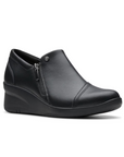 Black leather wedge ankle slip-on shoe. Has a detailed silver button above side zipper. Small detailed diagonal stitching on toe.