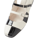 Toe of black and white shoe with two buckle straps.