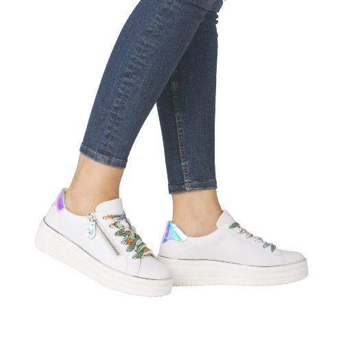 Model wearing white Remonte D1C06 lace-up platform sneakers with colorful laces and iridescent heel detail, styled with jeans.