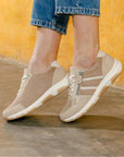 Model wearing Women's Remonte D1S04 sneakers in beige, styled with jeans, highlighting their casual, lightweight design for daily comfort.