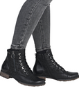 Black lace-up boots with side zipper worn with gray jeans.