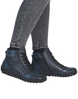 Blue sneaker boots worn with gray jeans.