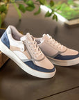 Navy and beige Women's Remonte D0J01 lace-up sneakers styled on a table, highlighting premium leather and casual elegance.