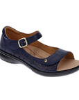 Navy blue floral perforated design on side of sandal with a gold buckle accent on Velcro strap, closed side and back, tan Revere logo'd footbed and black outsole.