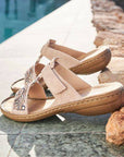 Beige Women's Rieker 608K2 Slide Sandals placed poolside, showcasing their stylish beaded design and summer-ready comfort.