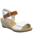 Rieker sling back wedge with blue back strap, brown buckle strap, white velcro toe strap, beige logo'd footbed and tan textured midsole.