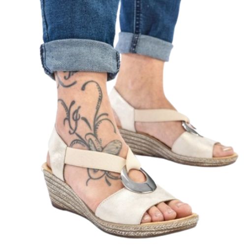 Model wearing beige Rieker 624H6 Sling-Back Wedge Sandals with tattooed ankle. Elegant and supportive for casual outfits.