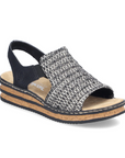 Backstrap Sandal with a black and white woven upper, side elastics, tan Rieker logo'd footbed, and faux cork midsole with black layers.