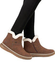 Model wearing Rieker 74260 women's ankle boots in brown, highlighting cozy faux fur collar and side zipper for easy winter wear.