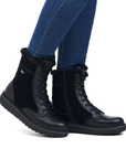 Black boots with fur lining worn with blue jeans.