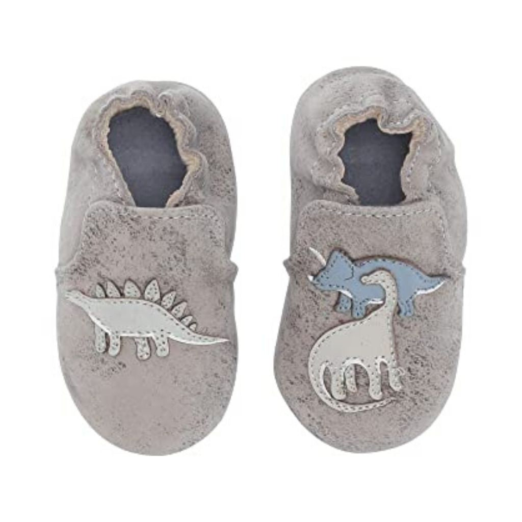 Looking down on grey leather pull on kids shoe with dinosaurs.