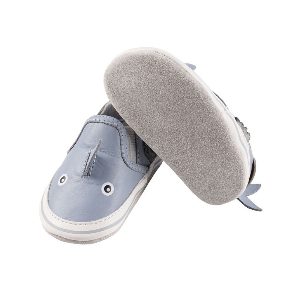 Right shoe shows soft grey bottom and left shoe shows  blue leather 3D shark kids shoe.