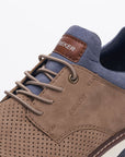 Close-up of tan casual shoes showing detailed stitching, lace design, and navy collar lining.