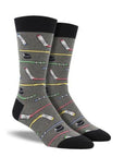 A pair of grey crew socks with hockey sticks and pucks on them.