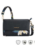 Black bag with floral print. Gold Travelon logo emblem is on the front flap.