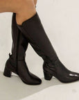 Women with crossed legs wearing the Josephine boot, which reaches just below the knee.