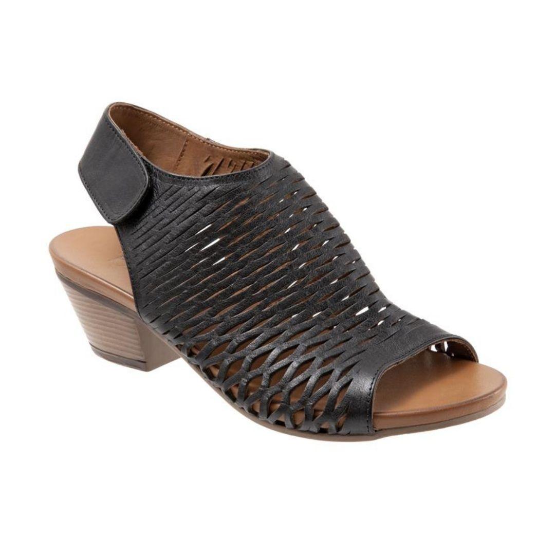 Lacey heeled sandal in black. Black leather perforated upper with velcro backstrap. Footbed is brown leather, with a 2 inch stacked heel.