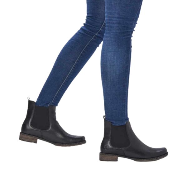 Legs wearing jeans and black leathre Chelsea boot with low heel.