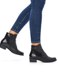 Model wearing black Women's Remonte D6882 lace-up boots with jeans, highlighting versatile style and ankle support for casual outfits.