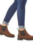 Model wearing brown Women's Remonte D8472 Chelsea Boots with jeans, highlighting ankle height and stylish waterproof leather design.