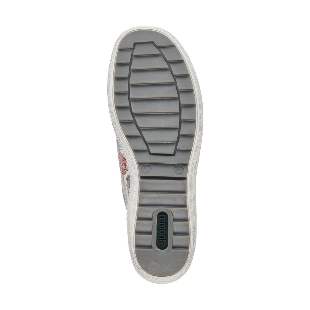 Grey outsole of women&#39;s sneaker with green Remonte logo on heel.