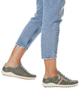 Model wearing green Women's Remonte R1432 Lace-Up Sneakers with jeans, demonstrating casual style and lightweight comfort.
