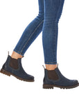 Model walking in navy Women's Remonte D8472 Chelsea Boots paired with jeans, showcasing waterproof leather and ankle boot silhouette.