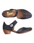 Pair of navy heeled open sided Mary-Jane with Velcro ankle strap, floral pattern, decorative perforations and a low stacked heel.