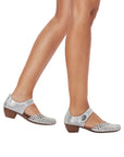 Silver leather Mary-Jane heels worn with bare legs.