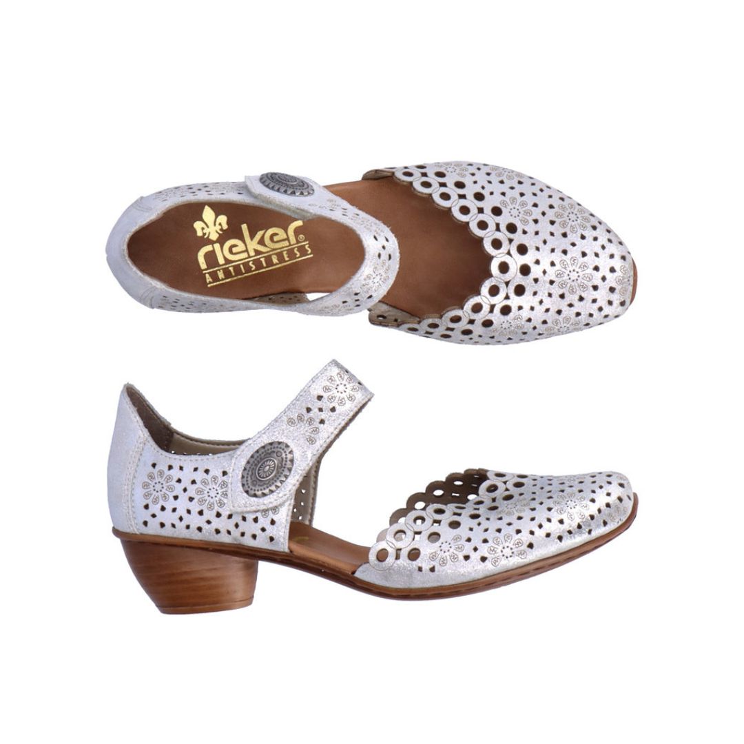 Pair of Silver heeled open sided Mary-Janes with Velcro ankle strap, floral pattern, decorative perforations and a low stacked heel.