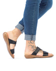 Black Rieker 60885 Slide Sandals modeled with jeans, showing flexible sole and supportive fit for casual outings.