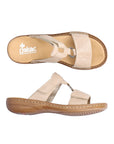 Pair of Beige slide sandals with two Velcro straps, textured details and medallion accent, tan Rieker logo'd footbed and brown outsole.