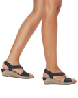 Model wearing black Rieker 624H6 Sling-Back Wedge Sandals. Comfortable and stylish wedge sandals for women on the go.