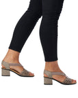 Model wearing taupe Women's Rieker 64677 Sling-Back Heeled Leather Sandal styled with black jeans, showcasing comfort and elegance.