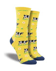 Yellow Women's Socksmith Legendairy Socks featuring black and white cows and floral accents. Stylish cotton crew socks for cow enthusiasts.