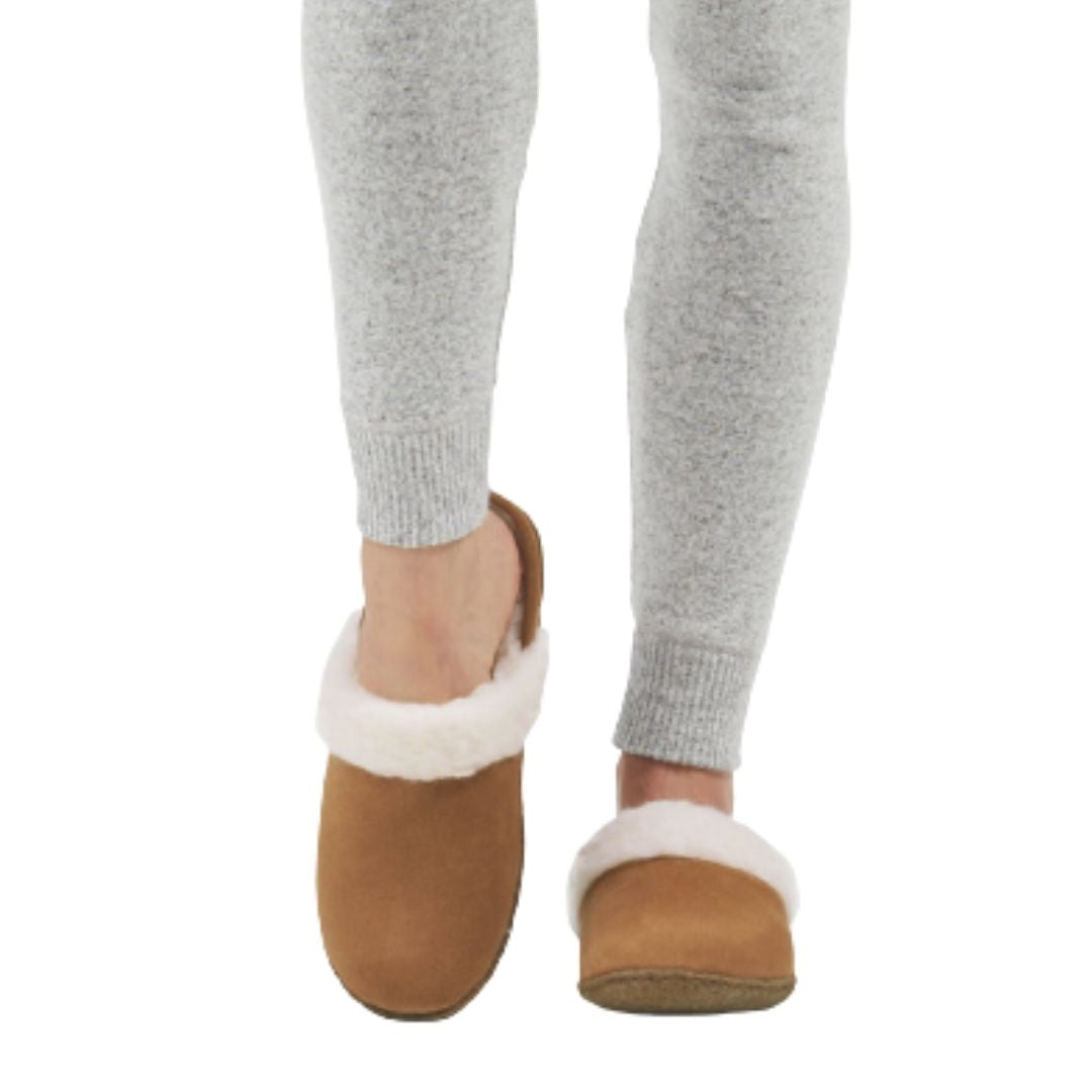 Model wearing Women's Sorel Nakiska Slide II Slippers, highlighting cozy faux fur trim and slip-on suede design for home wear.