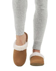 Model wearing Women's Sorel Nakiska Slide II Slippers, highlighting cozy faux fur trim and slip-on suede design for home wear.