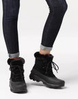 Model wearing dark jeans and black winter boots with lace-up front and thick rubber outsole.