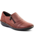 Brown slip-on women's shoe with a side zipper,  textured sole, and decorative folded leather across the front.