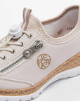 Close-up of beige Slip-On Sneaker showing detailed zipper, Rieker logo, and bungee lacing.