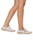Model walking in beige Slip-on Sneakers with faux cork-textured midsole and white outsole.