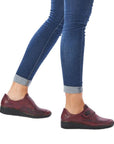 Model wearing red Rieker 537C0 slip-on shoes with jeans, showcasing casual fall style and lightweight wedge comfort.