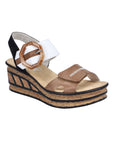 Black, white and brown straps on a wedge sandal with a faux buckle on top Velcro strap and a faux cork wedge midsole with black accent lines.