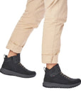Model wearing Men's R-Evolution U0170 Sneaker Boots in black, styled with beige pants for a casual and functional winter look.