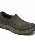 Battery Park in brown. Dark brown nubuck slip on shoe with apron toe stitching. Midsole is taupe, outsole is black.