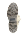 Bottom view of beige Anova Boot outsole with deep lugs for enhanced grip on snowy surfaces.