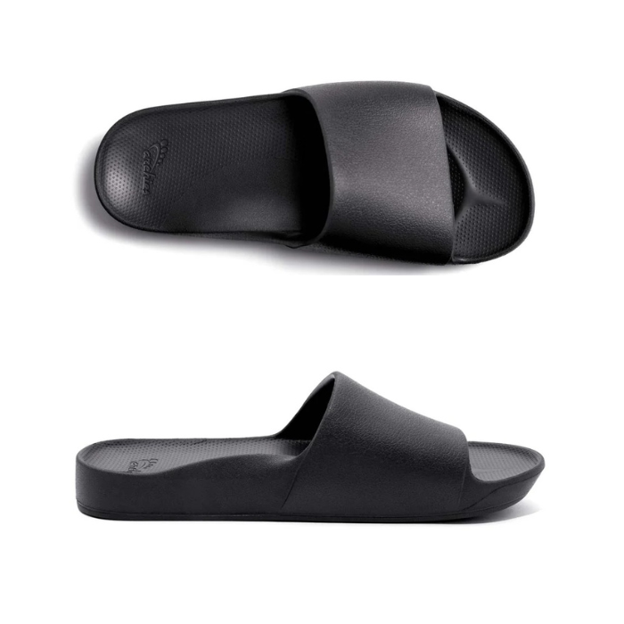 Pair of Black slide sandals with Archie logo stamped in heel.
