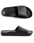 Pair of Black slide sandals with Archie logo stamped in heel.